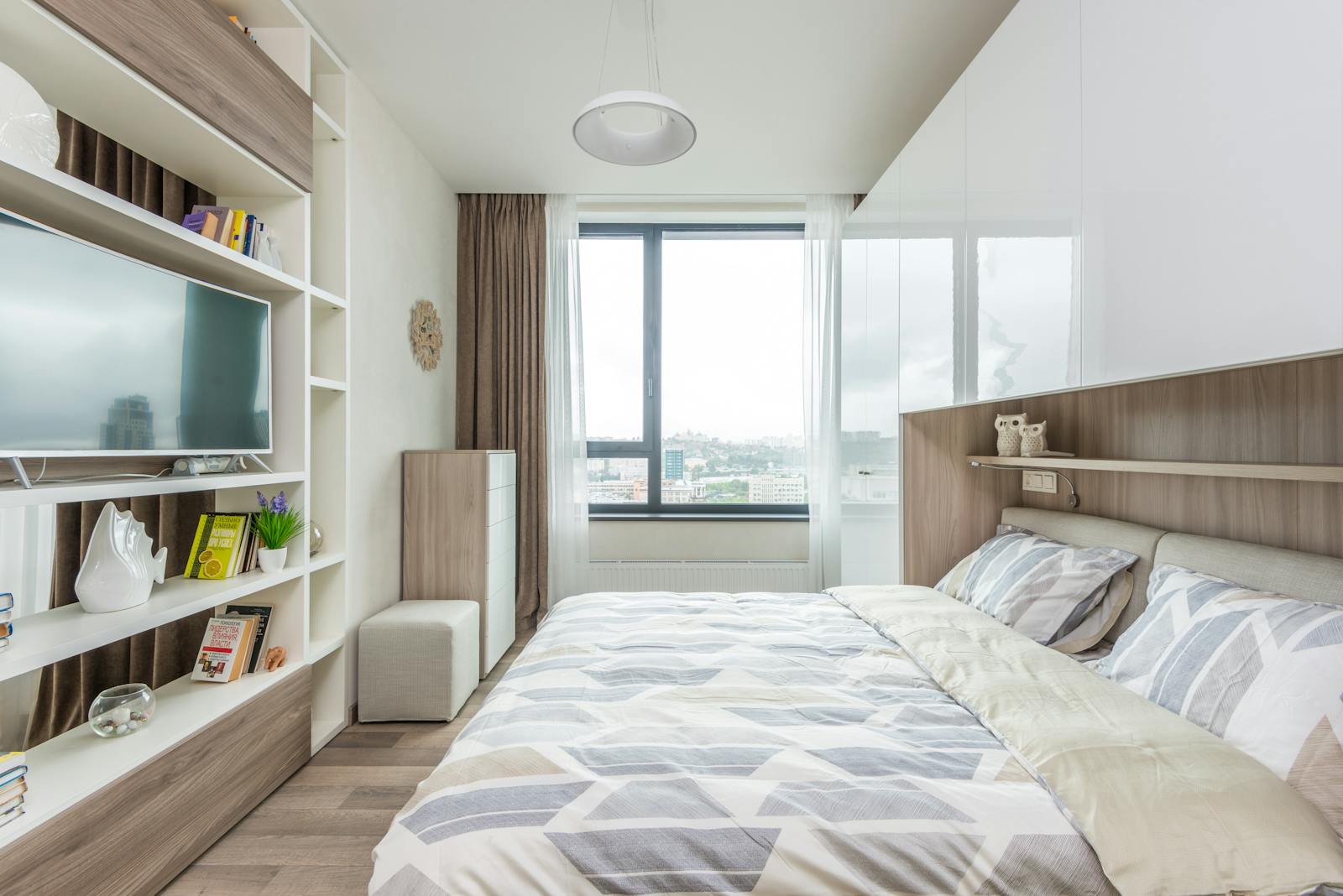 Bright and cozy modern bedroom with geometric decor and city view.